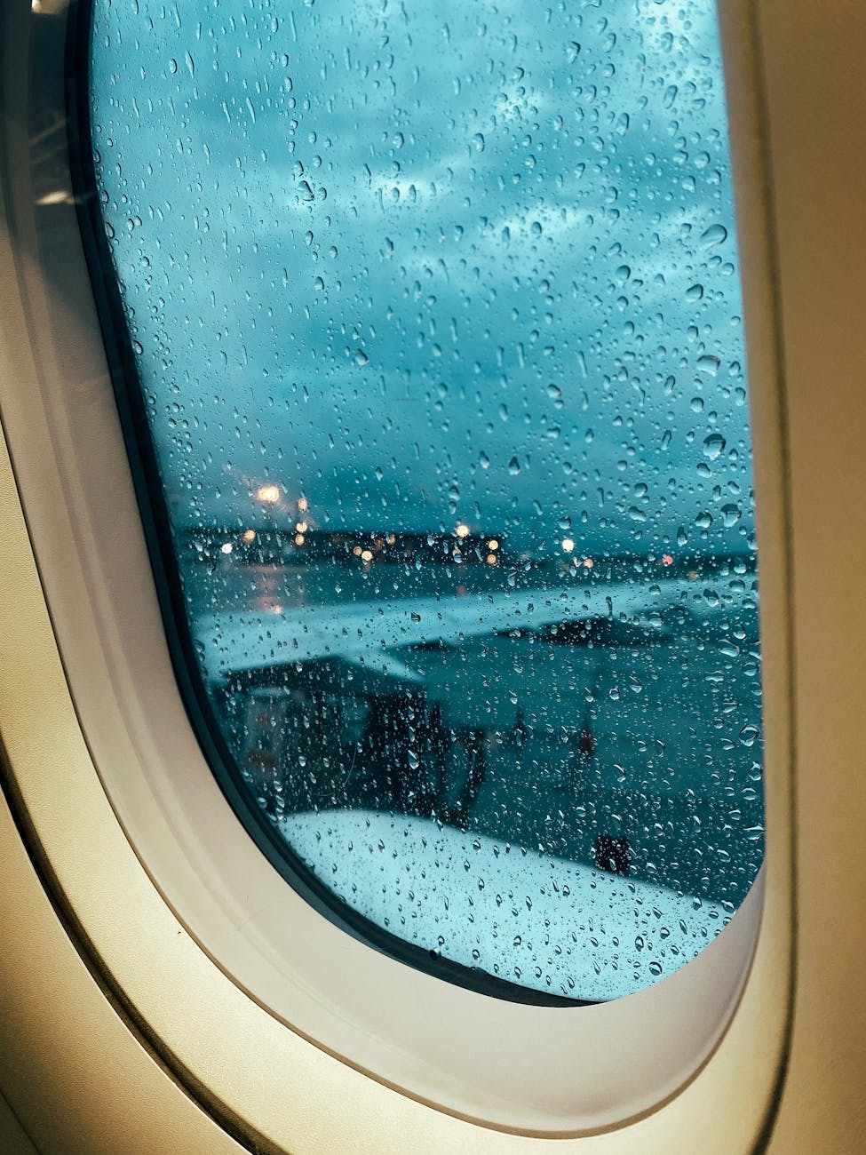 airport in rain seen through airplane window